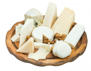 wooden plate with various cheeses